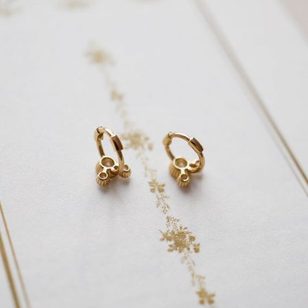 Detailed view of the sterling silver huggie hoop earrings, showing the intricate design and craftsmanship.