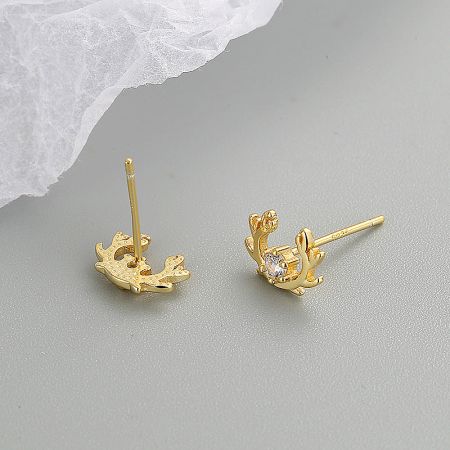 Detailed view of the gold elk antler earrings, highlighting the texture and a single clear gemstone.