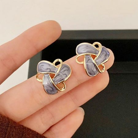 Unique gold butterfly or bow-shaped earrings with gray and white marbled stones.