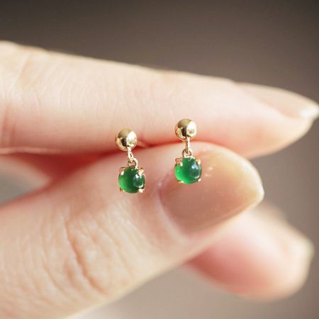 A pair of 925 sterling silver tiny jade earrings with a classic gold finish, highlighting the vibrant green gemstones.