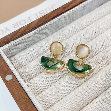 Gold earrings featuring off-white round stones and green half-moon stones.