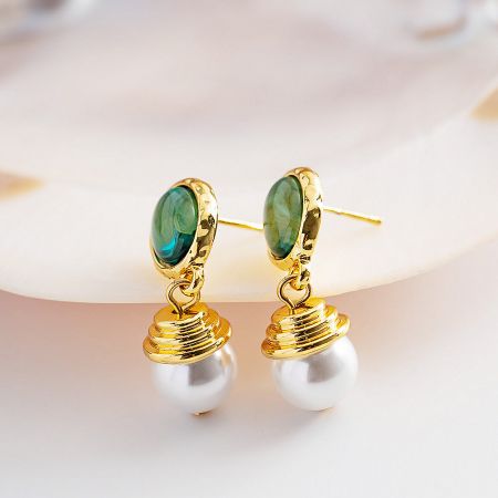 A pair of gold-plated stainless steel earrings with vibrant green malachite stones and elegant white pearls.