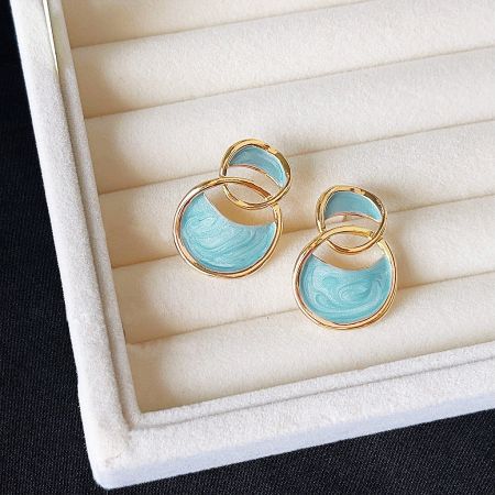 Elegant gold stud earrings featuring a light blue marble design.