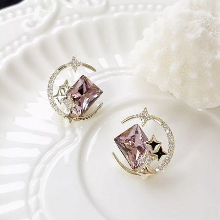 The complete set of five pairs of moon and star earrings elegantly arranged.