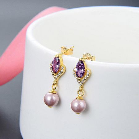 Full view of the elegant pearl drop earrings against a neutral background.