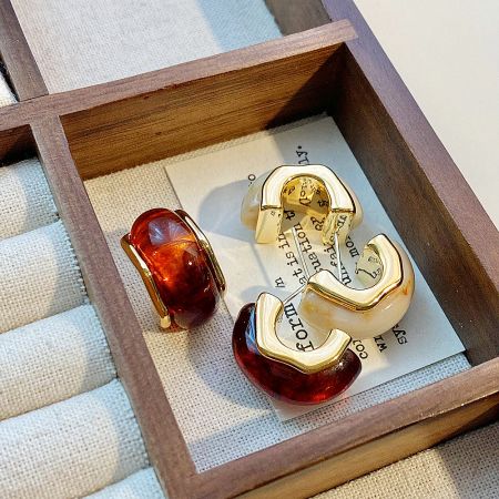 The set of C-shape stud earrings presented elegantly in a jewelry box, highlighting the gold plating.