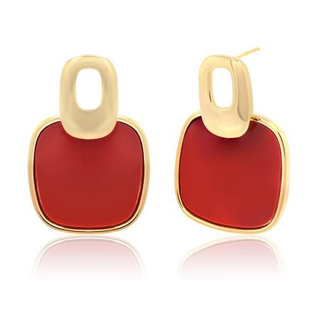 Detailed view of the gold earrings with red enamel, highlighting the oval-shaped loop and square base.