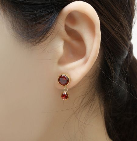 Detail shot of the matching stud earrings with fire red cubic zirconia stones.