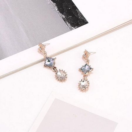 Side view of the geometric dangle earrings showing gemstone facets.