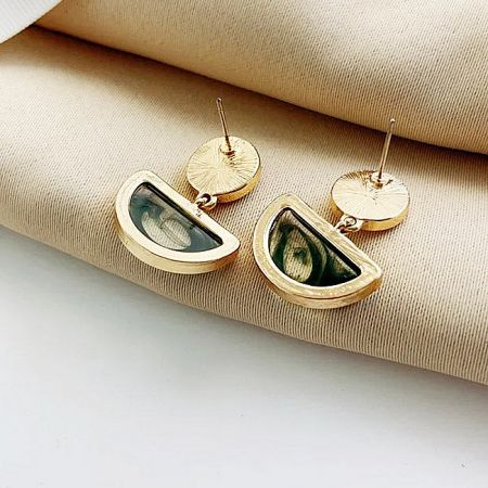 Modern gold earrings with unique triangular green stones.