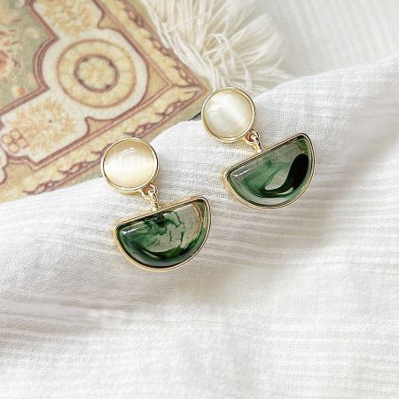 Elegant gold drop earrings featuring white and green stones.