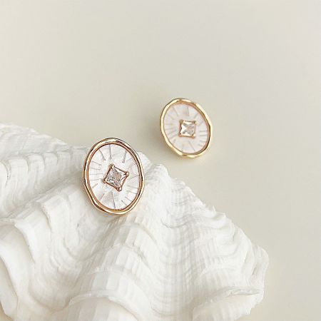 Gold Plated White Resin with Square Zircon Stone Stud Earrings (5 pairs) - A pair of gold-plated white resin stud earrings with square zircon stones, elegantly displayed on a seashell.