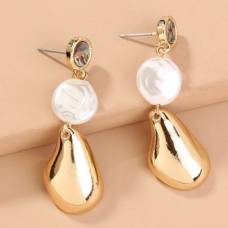 Angled shot of the gold baroque pearl earrings highlighting the white pearls and iridescent stones.