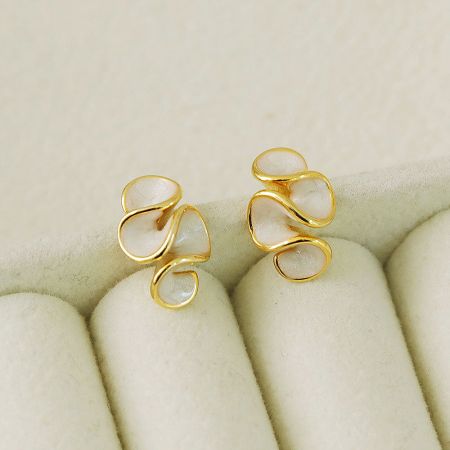 Elegant white enamel earrings with interconnected loop design on a velvet display.