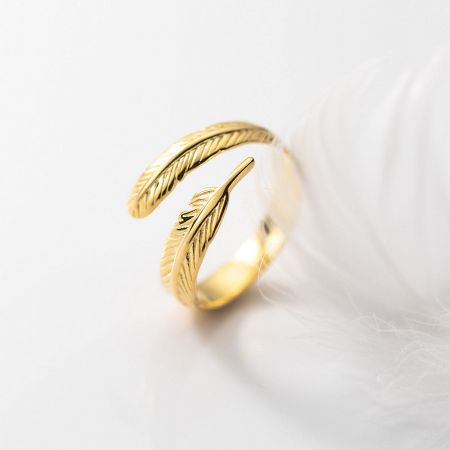 A close-up product shot of the gold feather ring, emphasizing its warm tone and detailed craftsmanship.