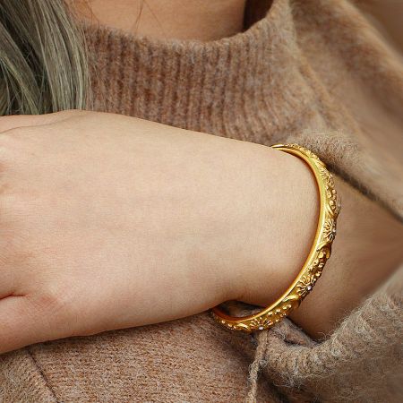 Model wearing the gold celestial-themed open cuff bracelet.