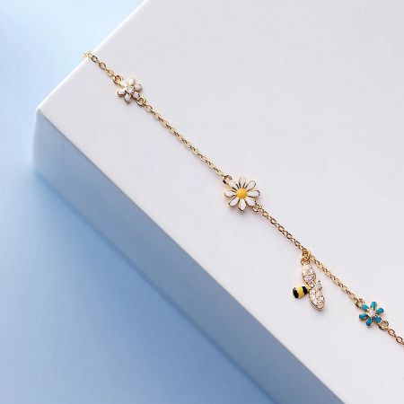 Another view of the gold charm bracelet, highlighting the sparkling zircon stones on the charms.