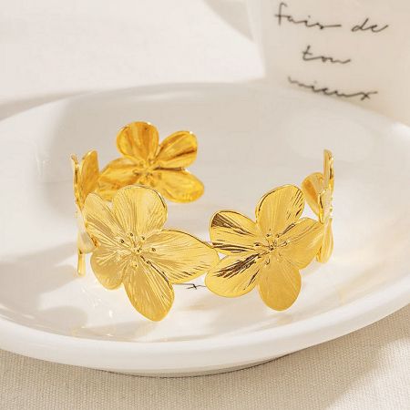 Front view of the stainless steel gold floral bracelet against a neutral background.