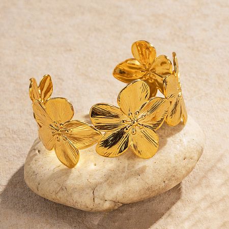 Detailed view of the gold floral cuff bracelet on a stone display.