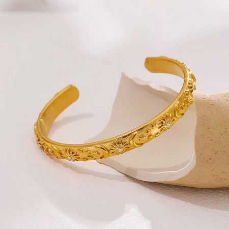 Close-up of the sparkling cubic zirconia gemstones on the gold cuff bracelet.