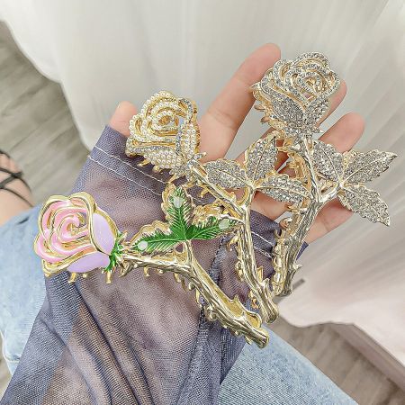A collection of three stunning rose-shaped hair clips in different designs and finishes.
