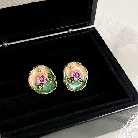 Set of 14k gold-plated floral earrings with pearls displayed elegantly in a black jewelry box.
