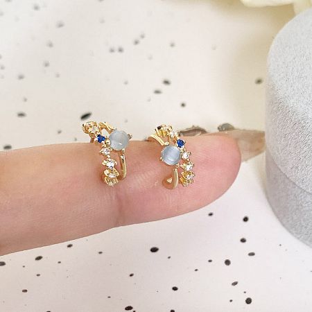 A pair of gold floral-designed earrings from the set, featuring delicate white and blue stones.