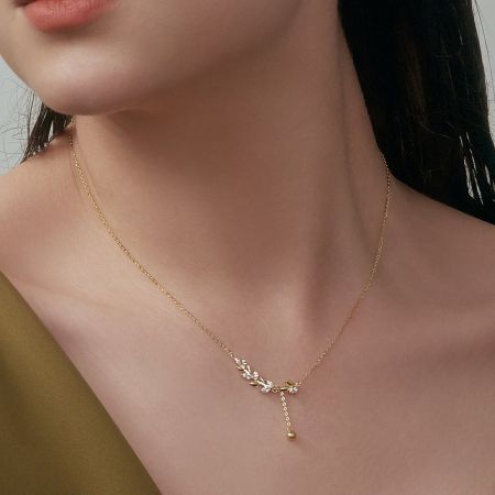 Detailed shot of the gold-plated version of the leaf tassel pendant necklace, highlighting the zircon details.