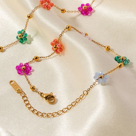 Detailed view of a gold chain bracelet with vibrant, multi-colored flower-shaped beads.