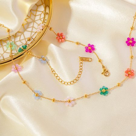 Detailed view of the gold floral necklace showing the lobster clasp and extender chain.