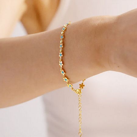 Stainless Steel Women's Blue Enamel Flower Chic Chain Boho Bracelets Set of 5 - A woman's wrist adorned with the stainless steel boho bracelet set, featuring delicate blue enamel flower charms.