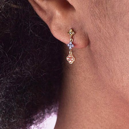 Detailed close-up of a single gold triple flower earring, highlighting the intricate craftsmanship and multi-colored elements.