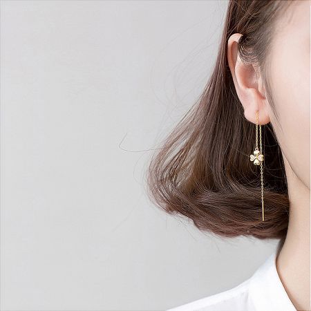 A close-up view of the four-leaf clover pendant, revealing the intricate zircon setting.