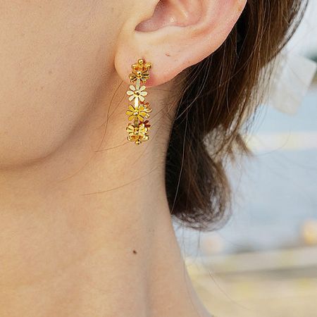 Close-up view of the intricate flower details on the gold C-shaped stud earring.