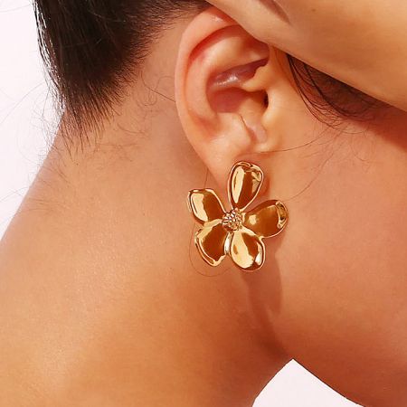 Side profile of a model wearing the gold daisy flower earring.