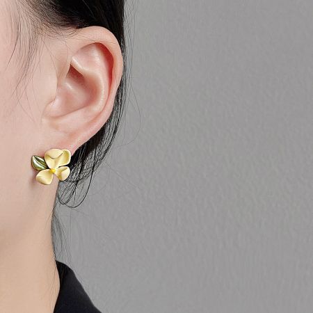 Close-up of the 3D Cape Jasmine flower earring on a woman's ear.