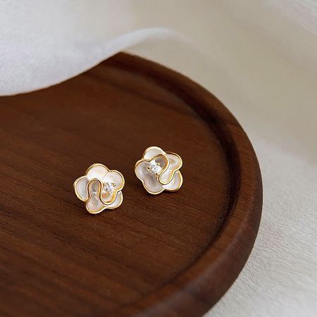 A clean product shot of the gold and white enamel flower earrings.
