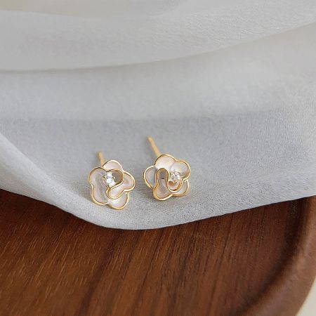 Detailed view of the gold flower stud earrings, highlighting the clear gemstone.