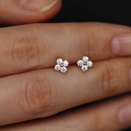 A pair of 925 silver four-leaf clover stud earrings with clear zircon gemstones on a white background.