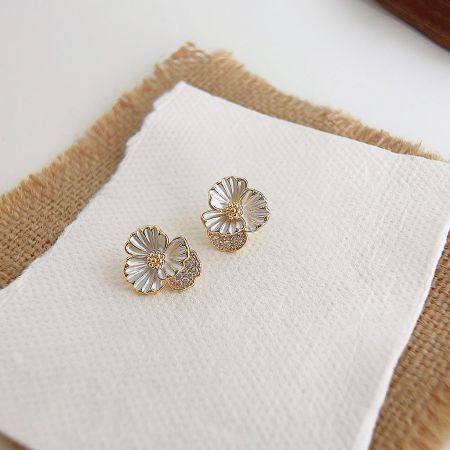 Promotional shot of the gold and white zircon flower stud earrings.