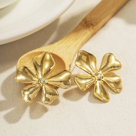 Detailed shot of the gold flower earrings showcasing the central diamond accents.