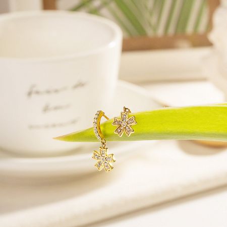 Another view of the gold flower-shaped earrings showcasing their sparkle.