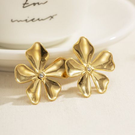 Front view of the gold flower stud earring with a central gemstone.