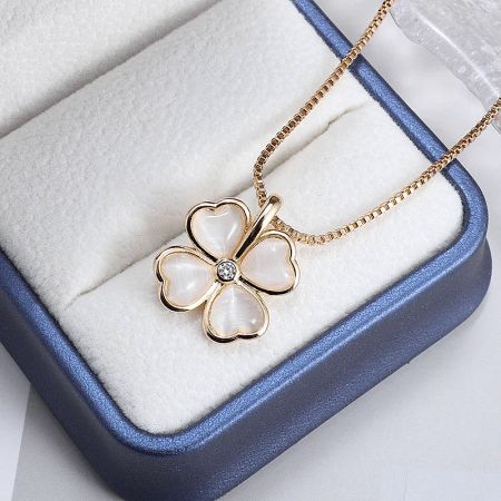 Charming gold necklace with a flower pendant composed of four heart-shaped cat-eye stones.
