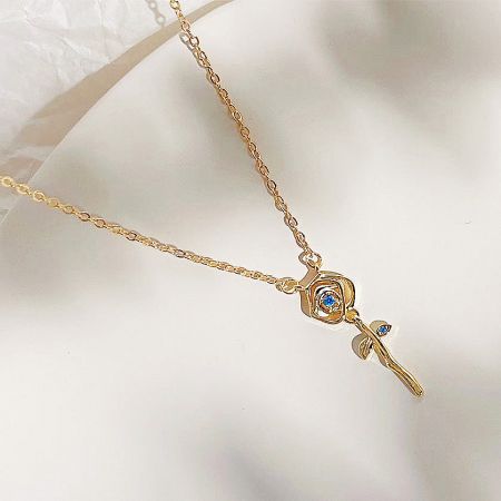 Full view of the gold flower pendant necklace with multiple blue gemstones.