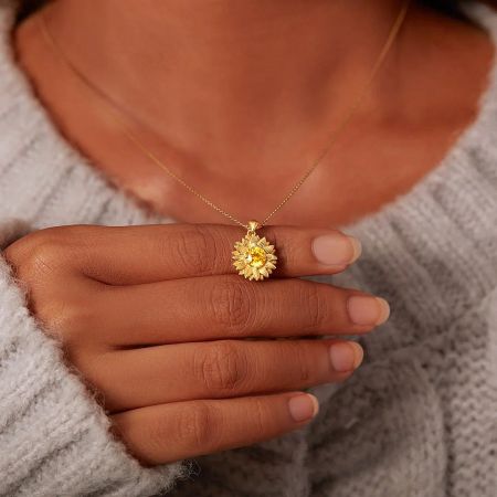 Detailed view of the gold-plated sunflower pendant with a brilliant central yellow zircon.