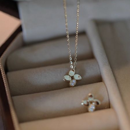 The lucky four-leaf flower necklace and matching earring set, presented as a perfect gift for special occasions.