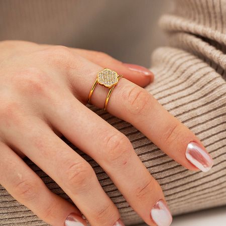 Close-up of a gold-plated ring with a delicate flower design paved with cubic zirconia.