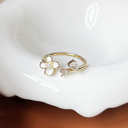 A unique gold ring from the set, showcasing a detailed flower with multiple gemstone accents.