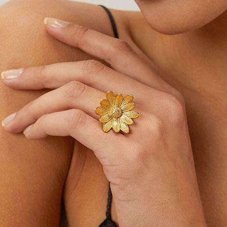 Stainless Steel 3D Daisy Sunflower Rings Set of 5 - A close-up of a woman's hand wearing the elegant gold-finished stainless steel 3D daisy sunflower ring.